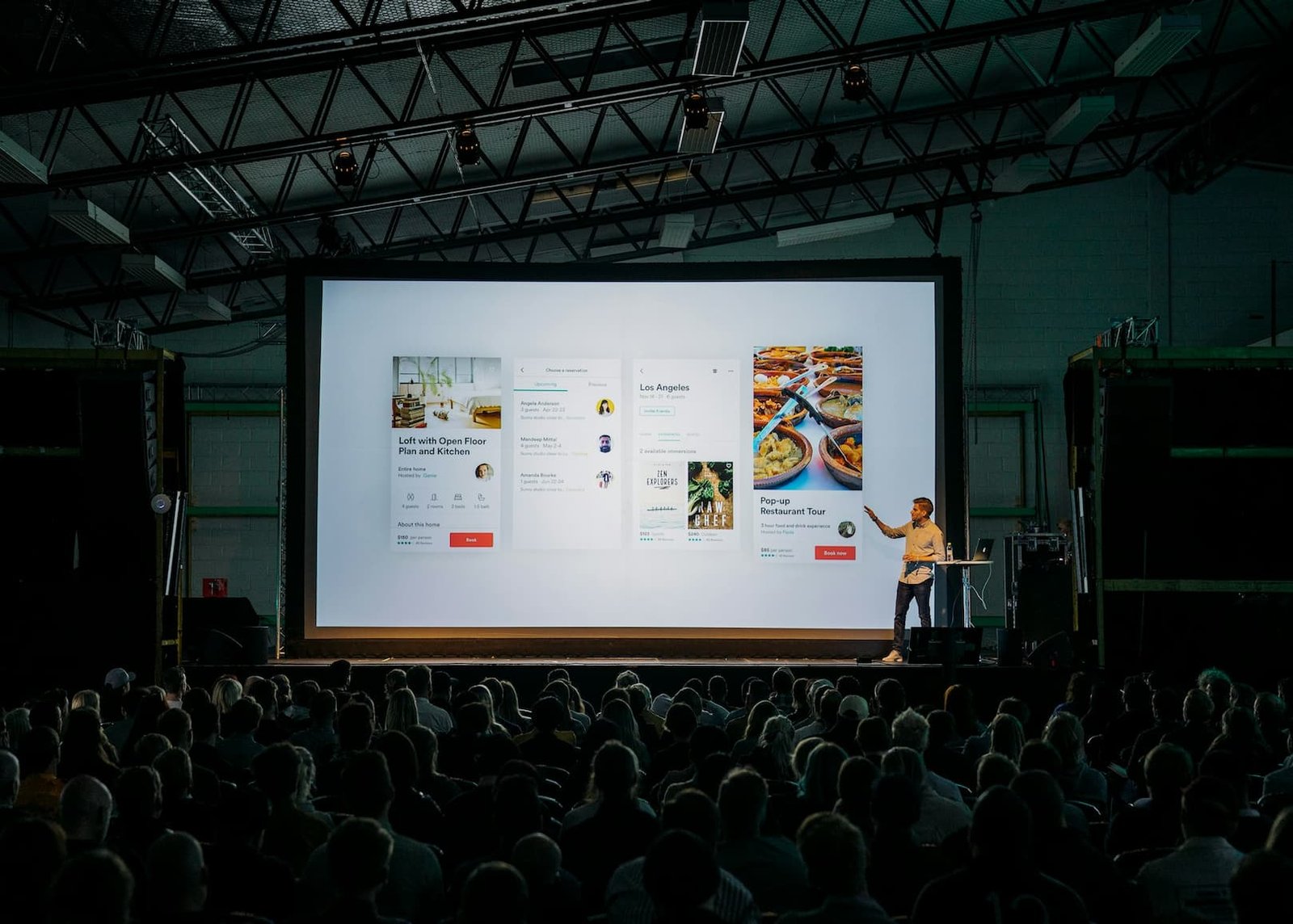 A man delivers a presentation in front of a large screen, engaging the audience with visual aids and clear communication.